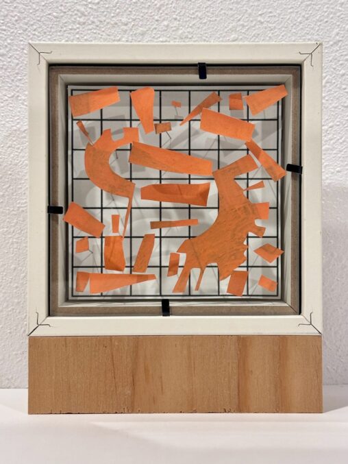 Everything In Its Right Place, assemblage by Laura Kinney with orange cut paper pinned to a printed grid in a found frame on plywood