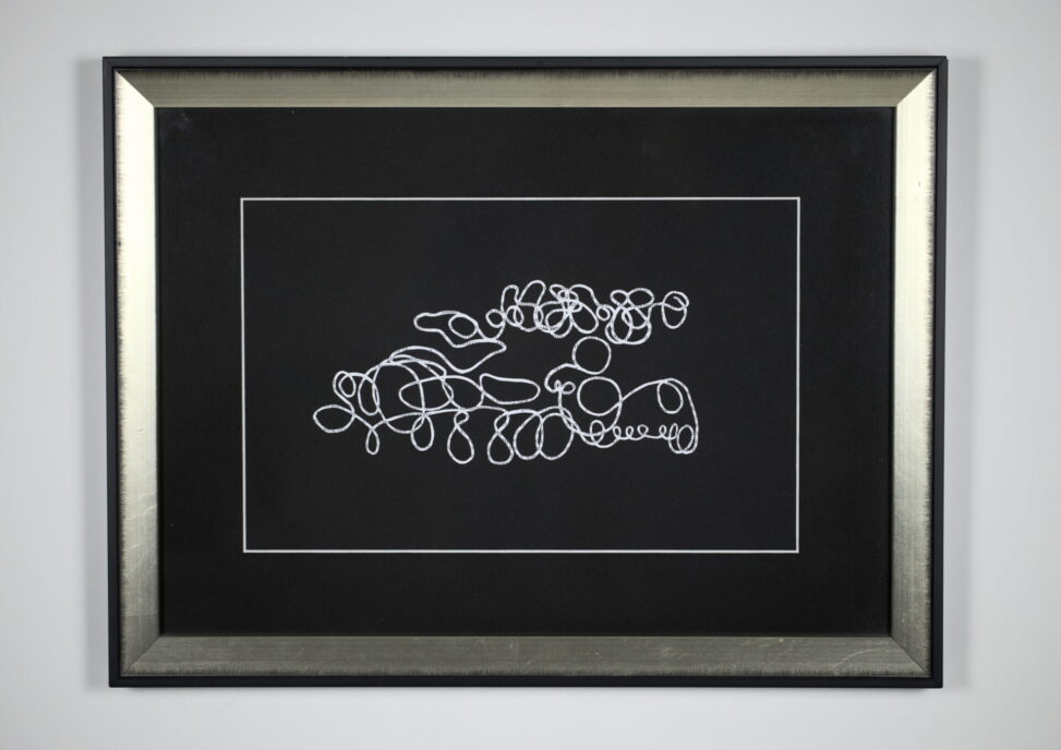 Paper Skull, cut paper artwork by Laura Kinney with white looping blind contour form on black mat, in a silver and black frame