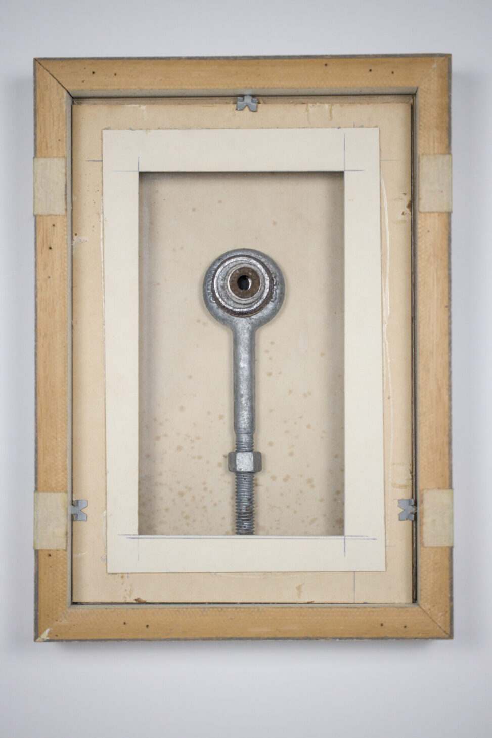 Portrait, assemblage by Laura Kinney with found eye bolt and rusty washers on glass in a reversed wood frame